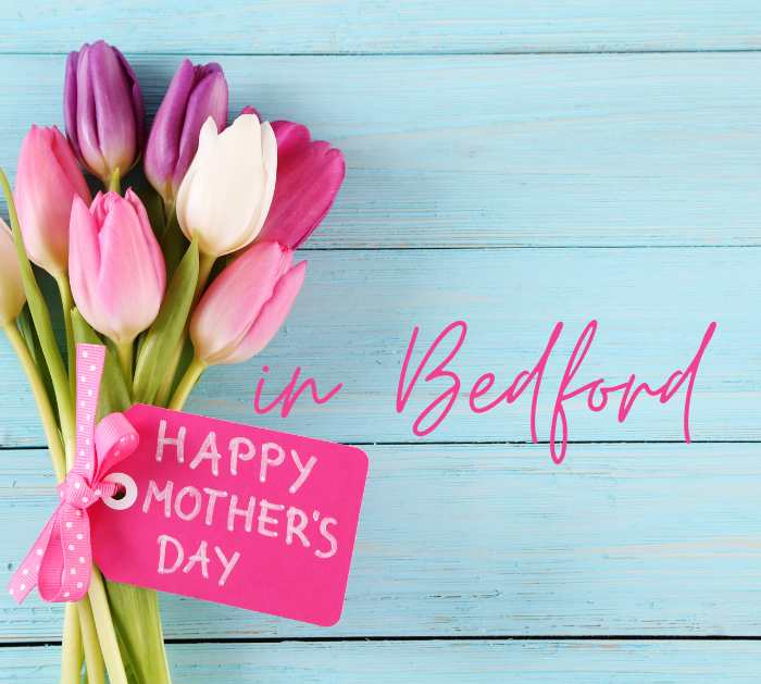 A blue background with a bunch of tulips and the words Happy Mother's Day