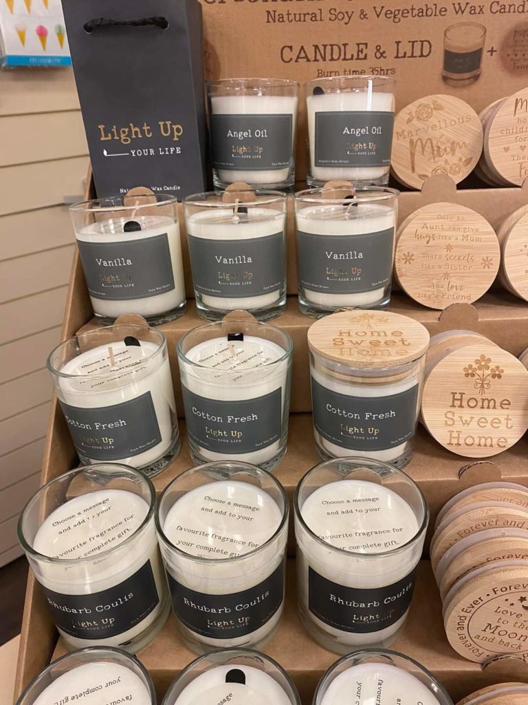 White candles in small glass containers. small wooden circular place mats
