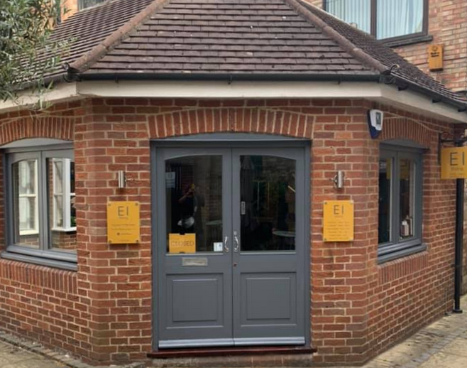 EI Styling shopfront, cottage shaped building with yellow signage and medium grey windows and doors