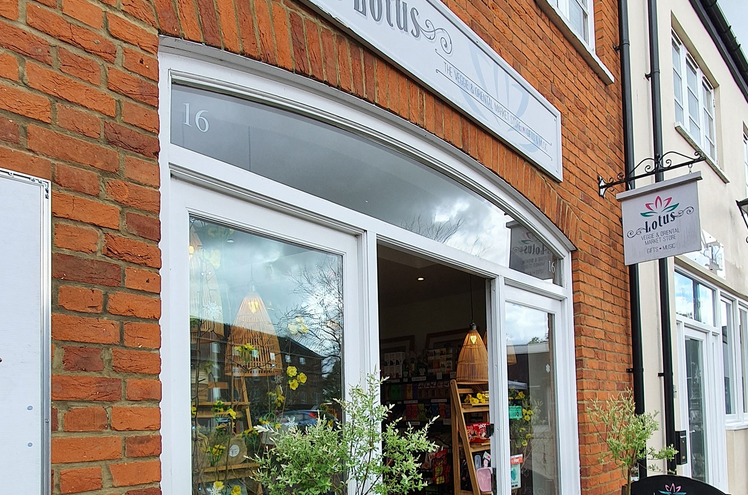 Lotus shopfront in period building, brown bricks, white timber framwork with plants and trees outside