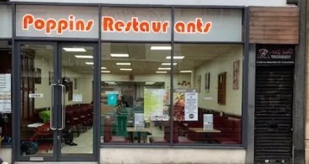 Poppins shopfront with orange retro signage with windows showing interior