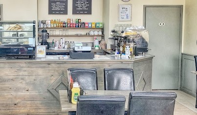 River Coffee interior with soft green and natural wood with counter, tables and chairs
