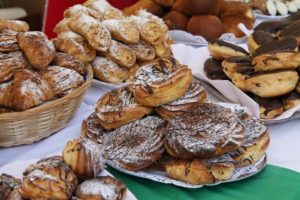 A selection of pastries and baked goods on plates and in small table baskets