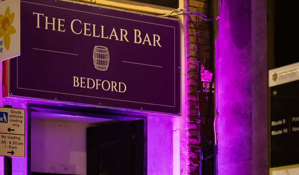 Cellar Bar front door with signage and purple lighting