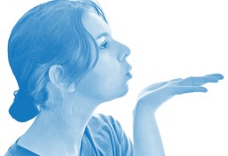 Lady's head viewed from the side blowing a kiss